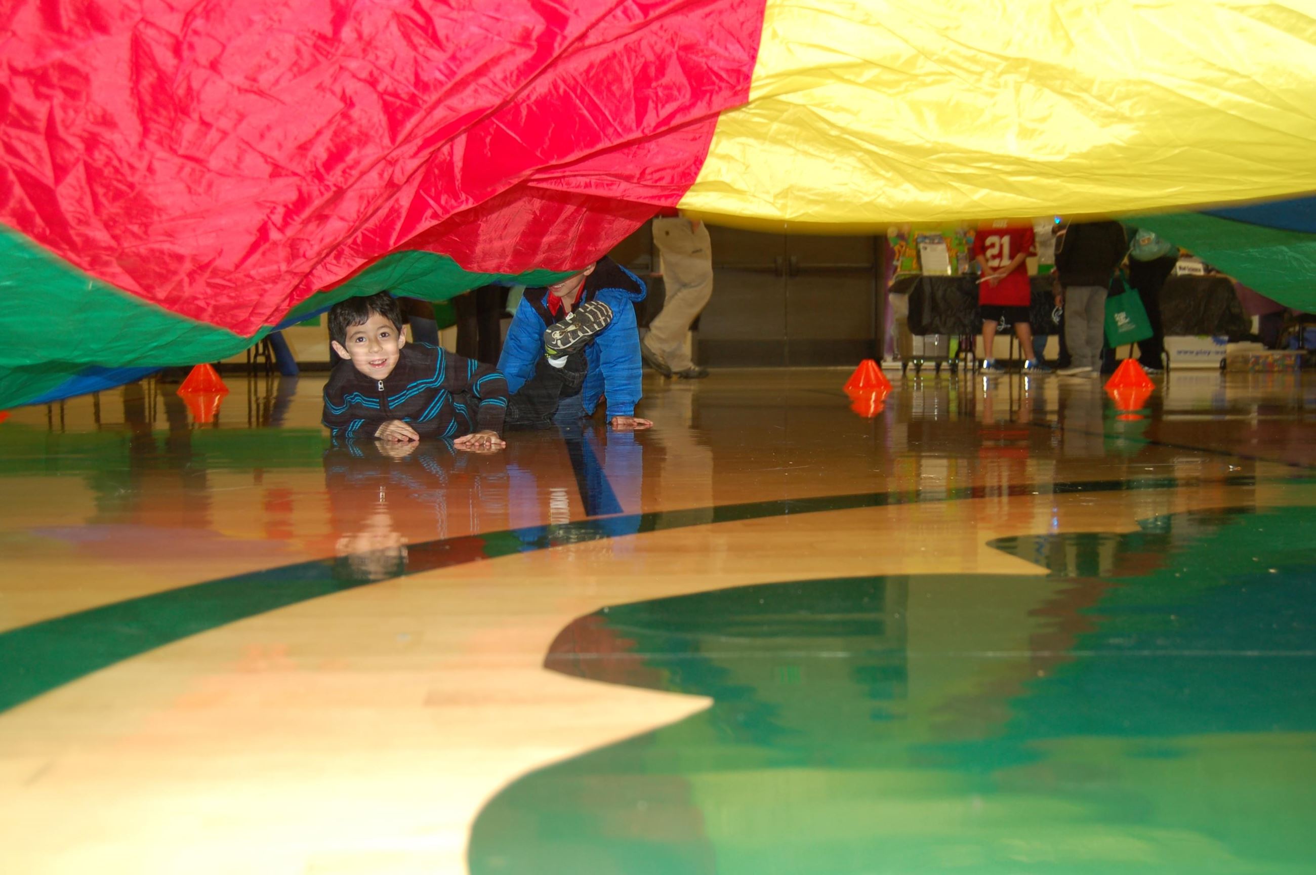 Boy laying on floor under parachute
