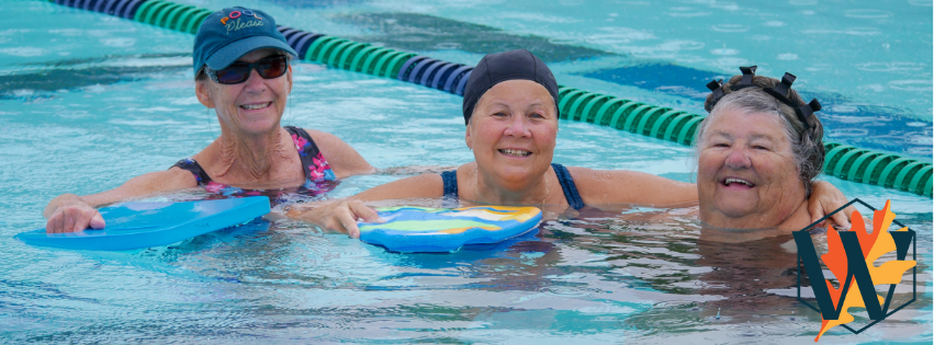 Three women in the pool smiling at the camera