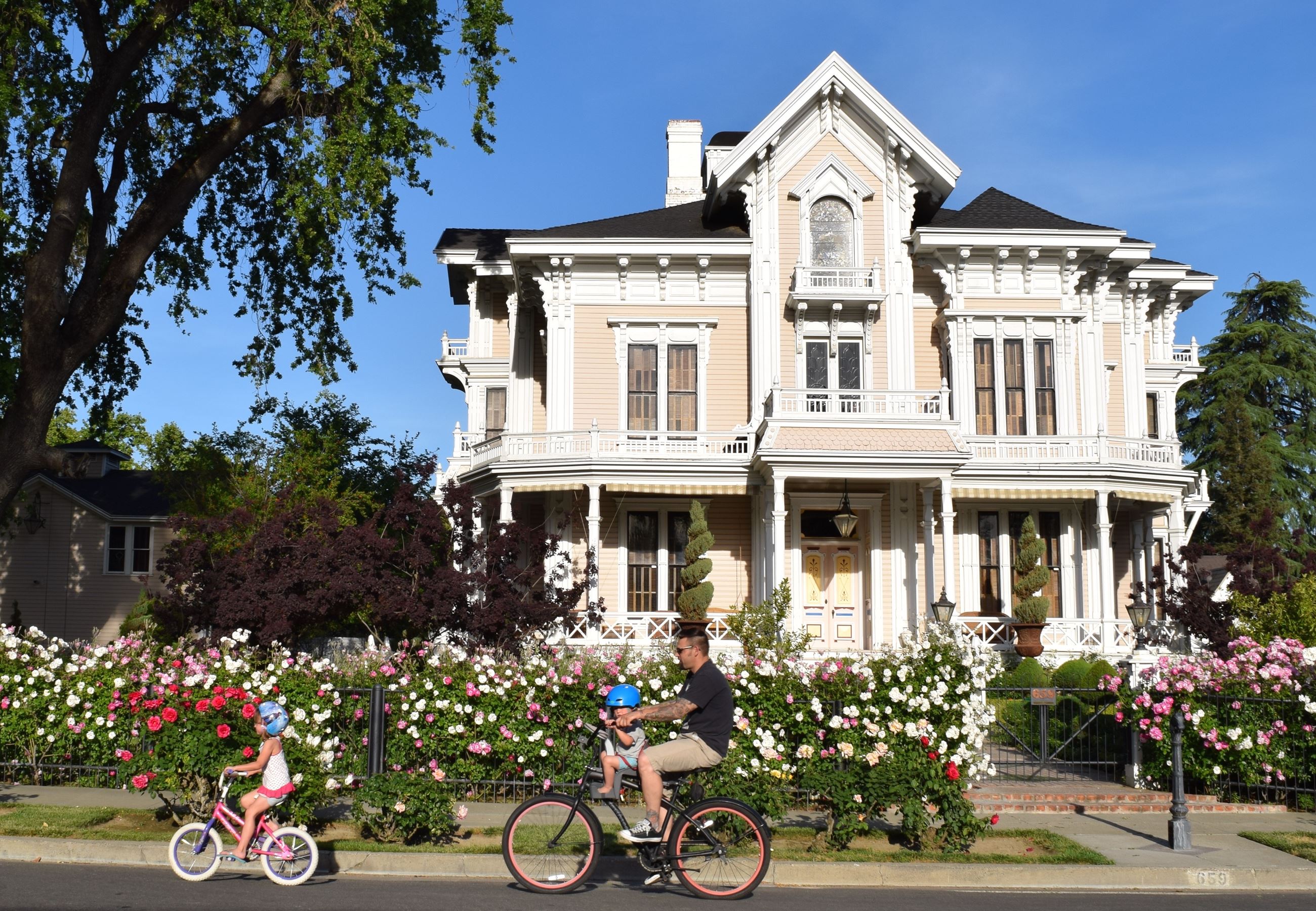 Family Biking in Front of Gable Mansion