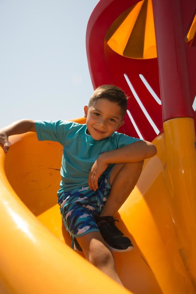 Boy Going Down Slide