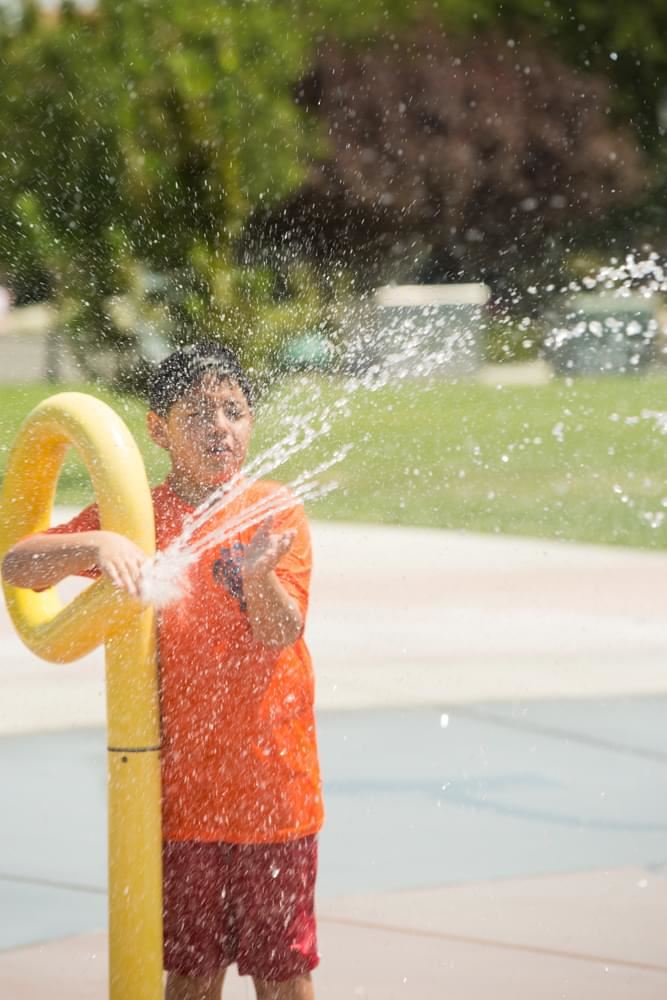 Boy Shooting Water Out of Splash Pool Feature